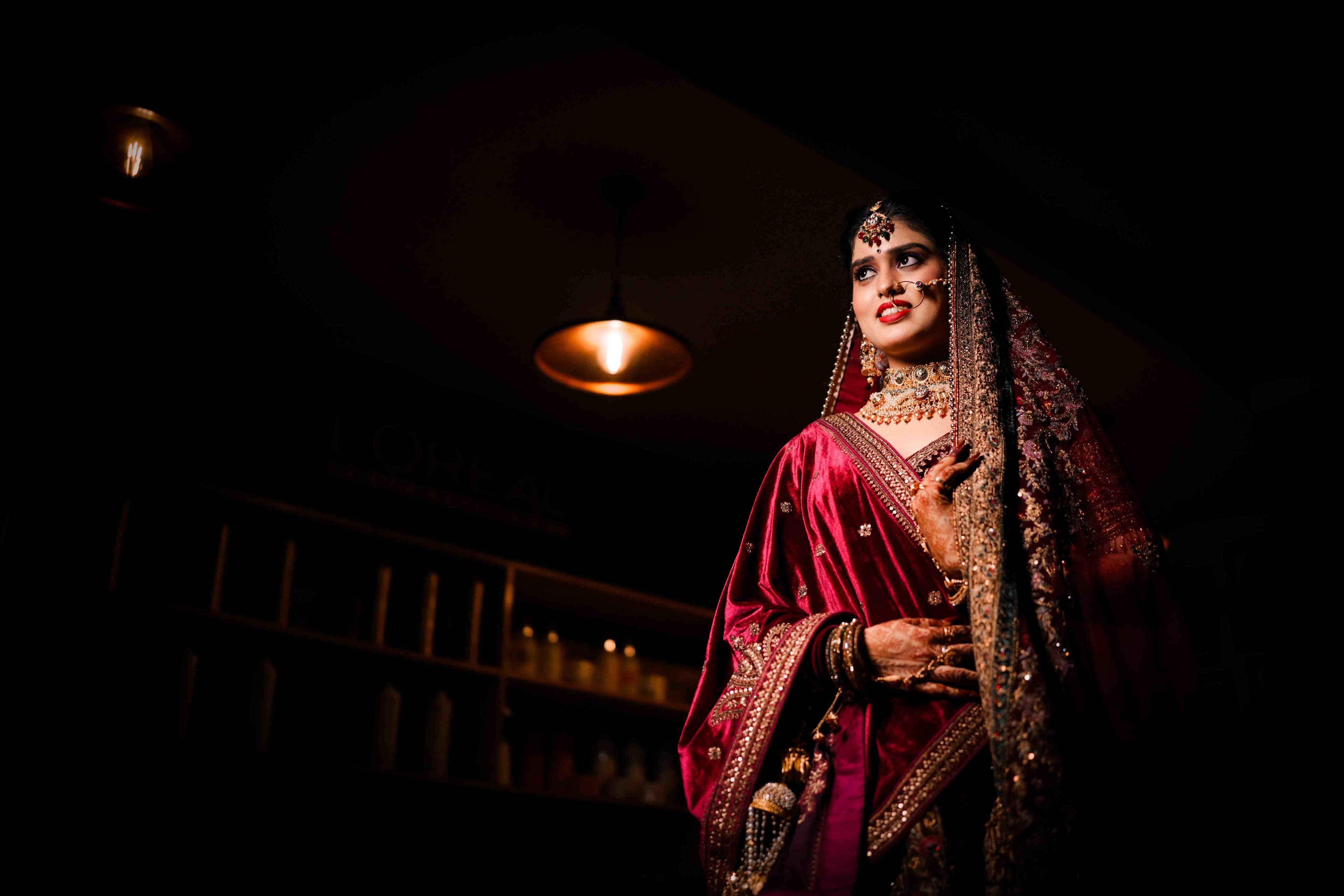 A beautiful bride adorned in a rich red and gold sari, embodying grace and happiness as she celebrates her wedding